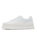 Women's white and black chunky platform shoes with back lacing and a thick rubber sole.