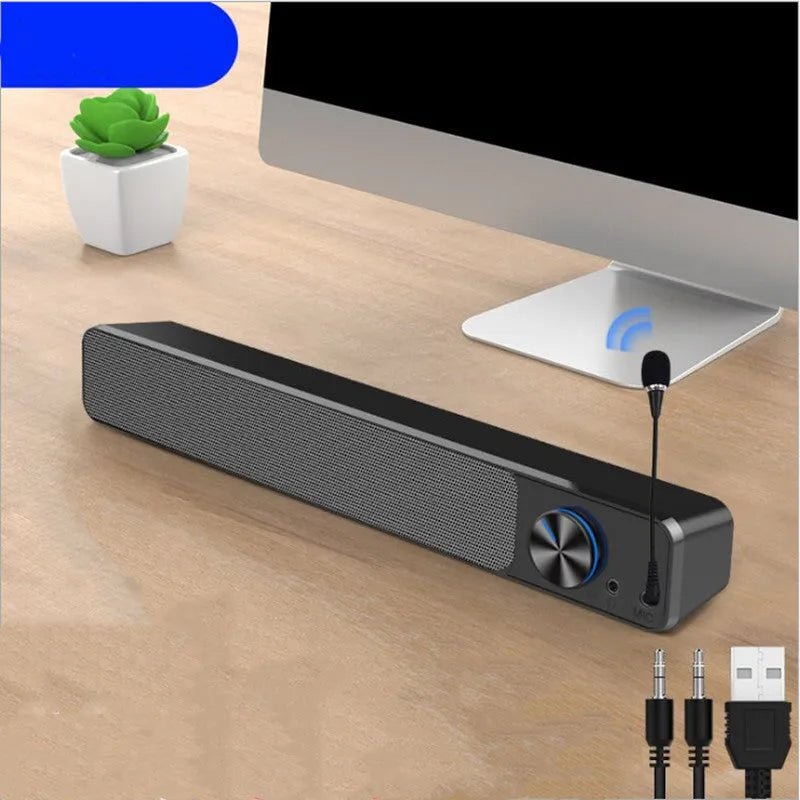 Small black computer speaker with USB cable on desktop