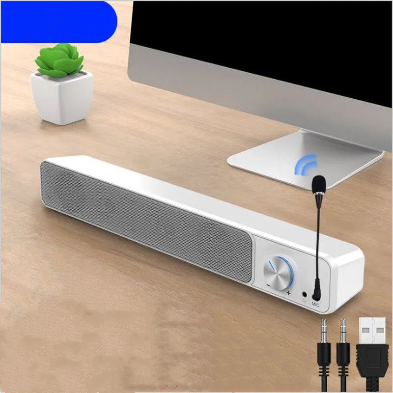 Small black computer speaker with USB cable on desktop