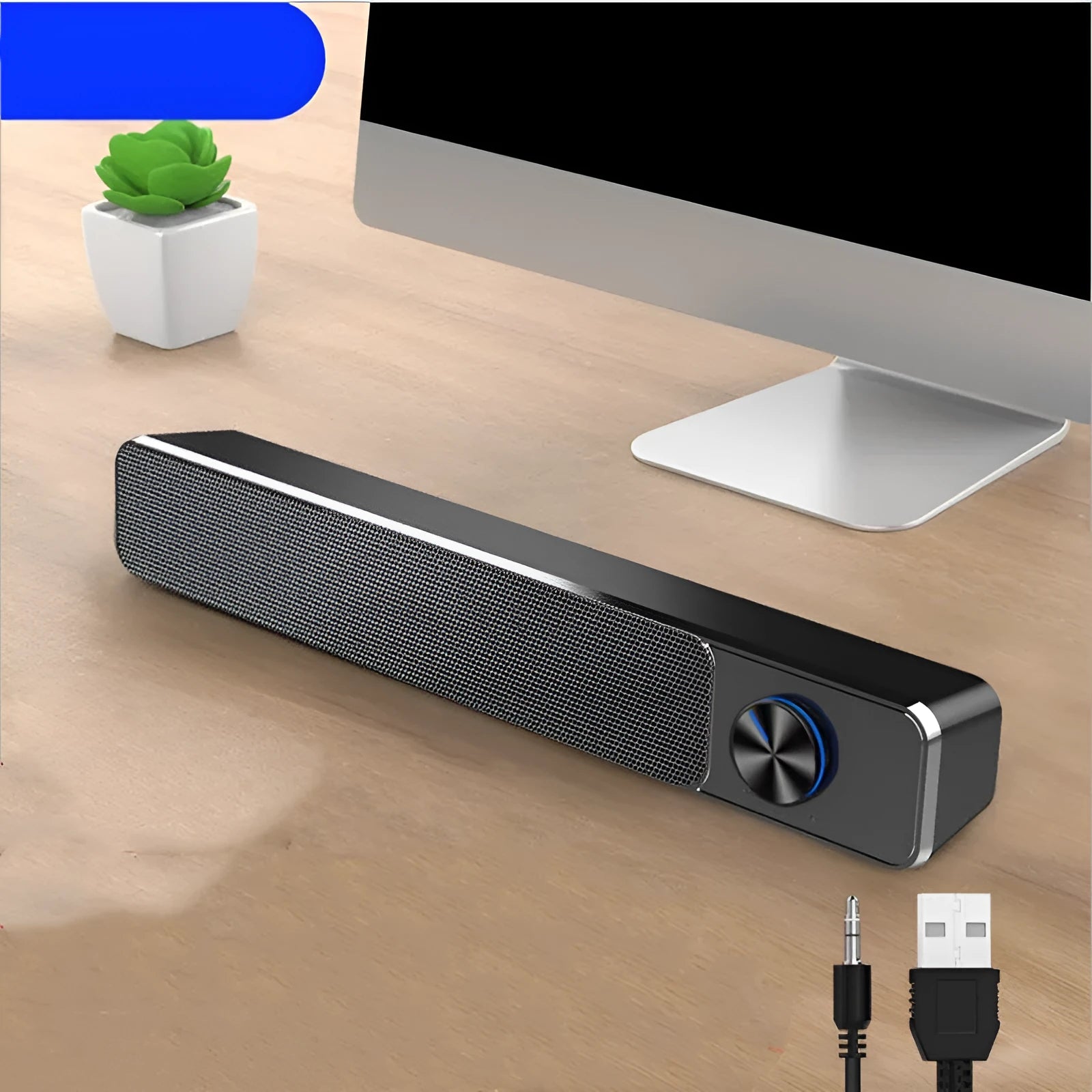 Small black computer speaker with USB cable on desktop