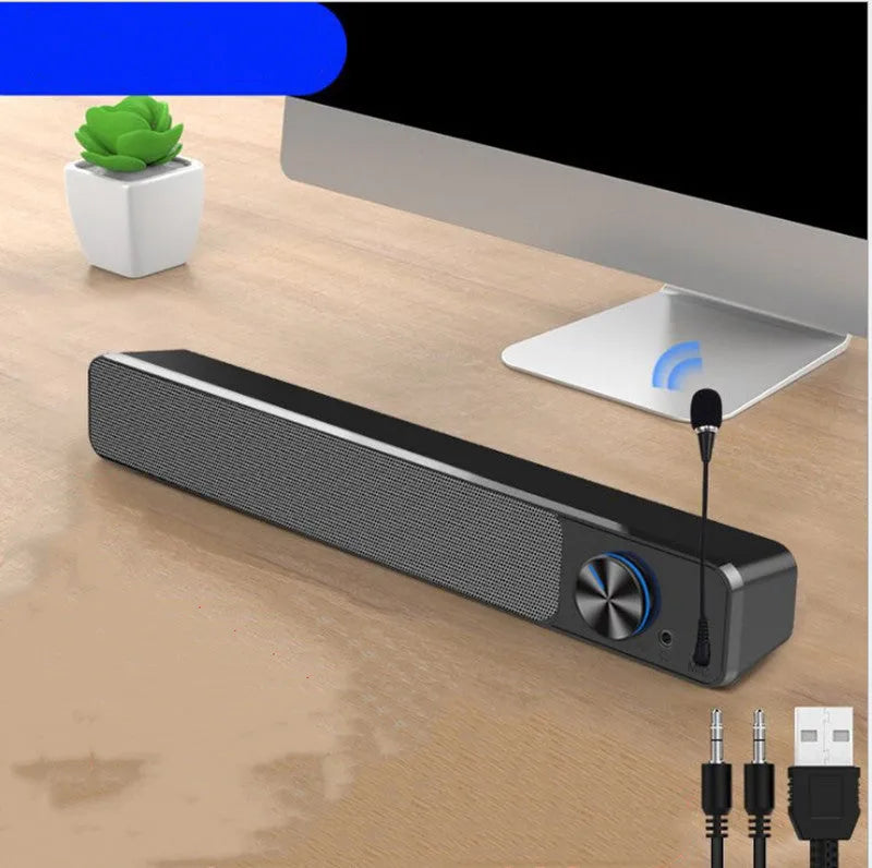 Small black computer speaker with USB cable on desktop