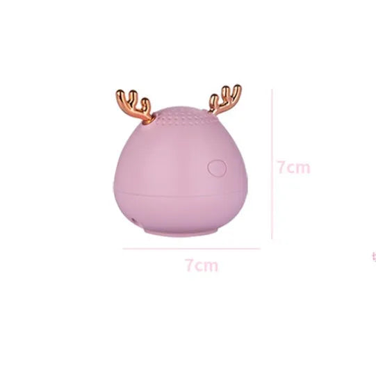 Small rectangular portable Bluetooth speaker in green, pink, or white with USB charging cable.