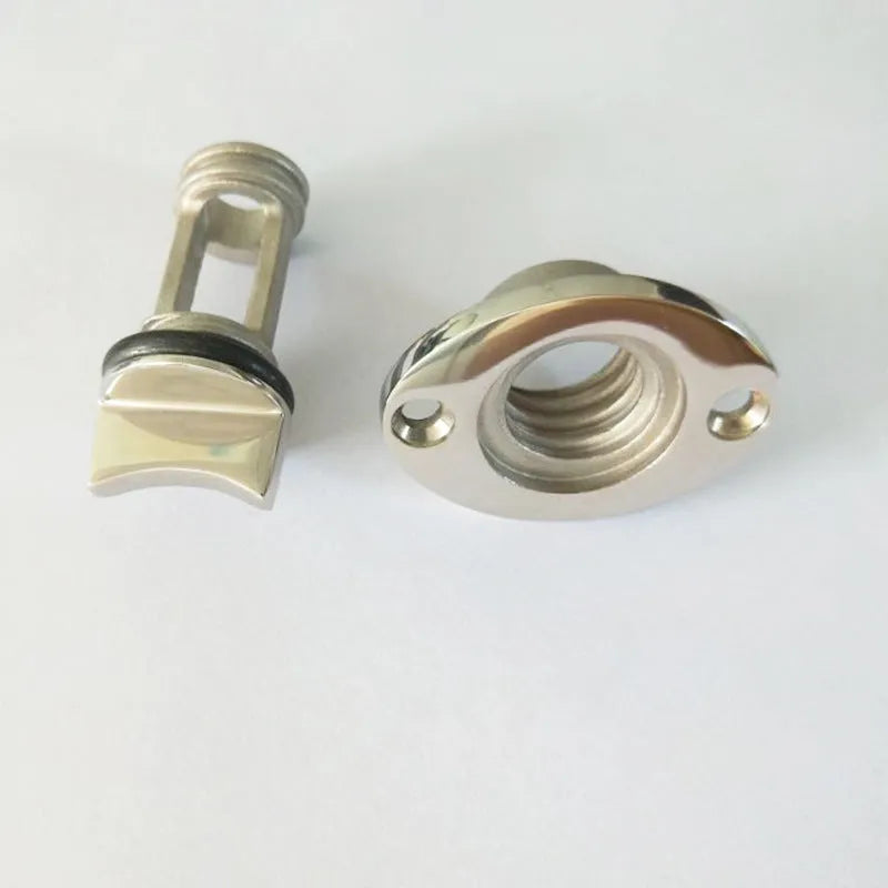 Stainless steel marine deck water plug with brass screw, shown next to a ruler for scale.