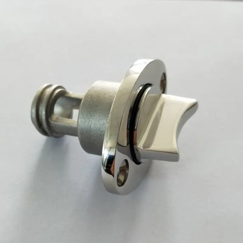 Stainless steel marine deck water plug with brass screw, shown next to a ruler for scale.
