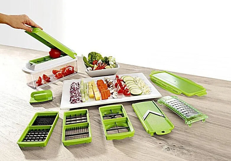 Green manual food chopper with multiple stainless steel accessories on a kitchen counter.
