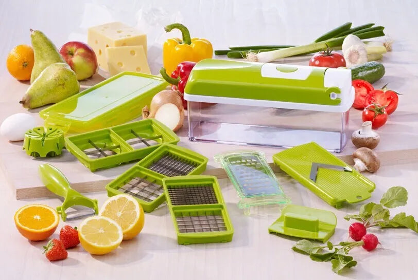 Green manual food chopper with multiple stainless steel accessories on a kitchen counter.