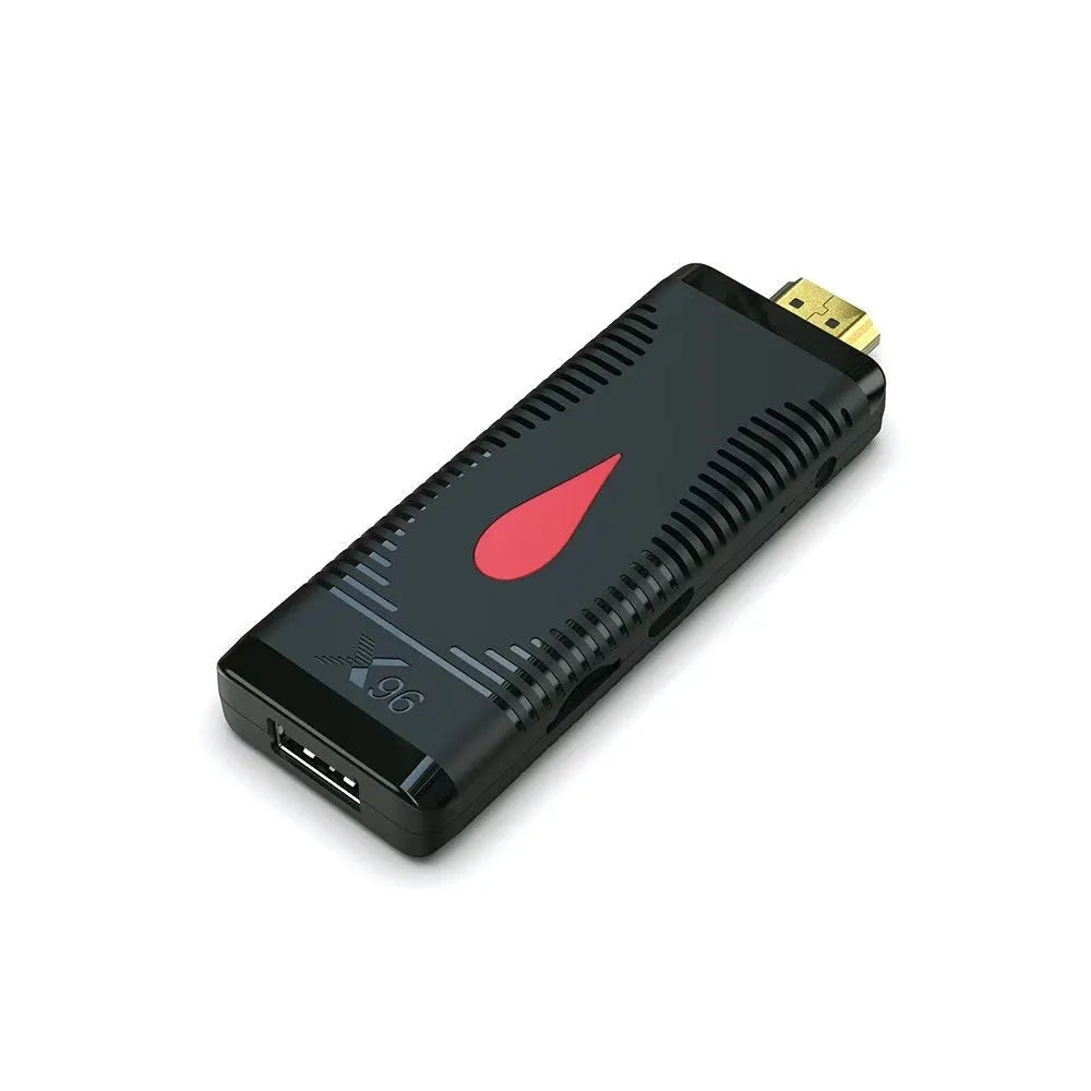 Android smart TV set-top box dongle with remote and cables on a wooden surface.