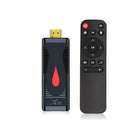 Android smart TV set-top box dongle with remote and cables on a wooden surface.