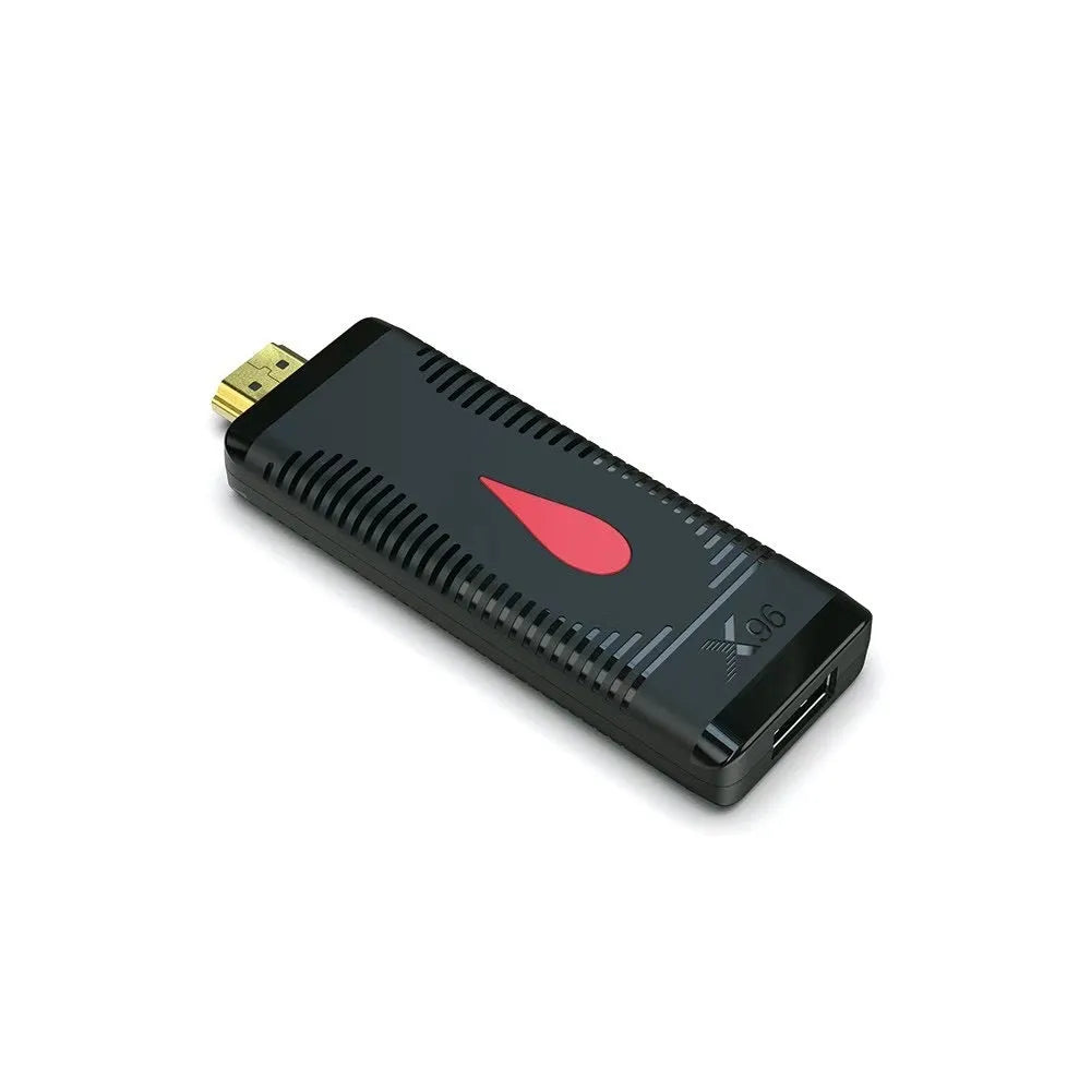 Android smart TV set-top box dongle with remote and cables on a wooden surface.
