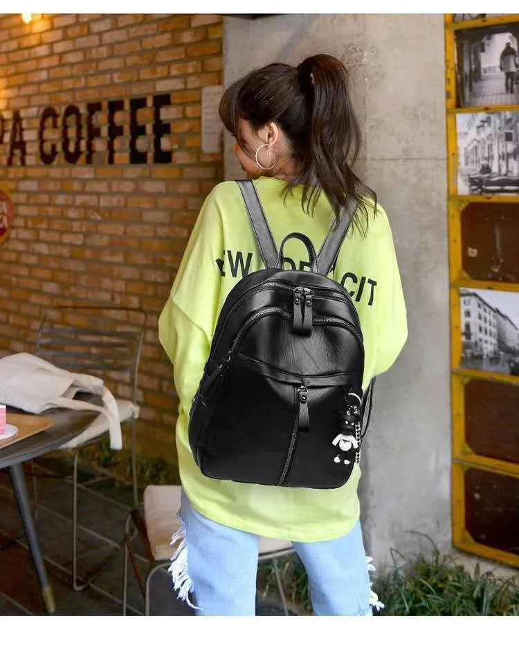 Black medium-size PU leather soft surface backpack with double straps and a zipper opening