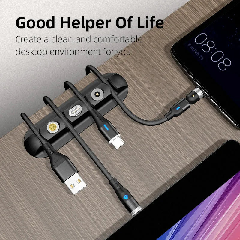 Black desktop magnetic cable organiser with soft plastic base on a desk.
