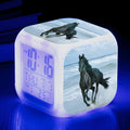 Square cartoon digital alarm clock with colour changing LED display on a plastic and plexiglass body.