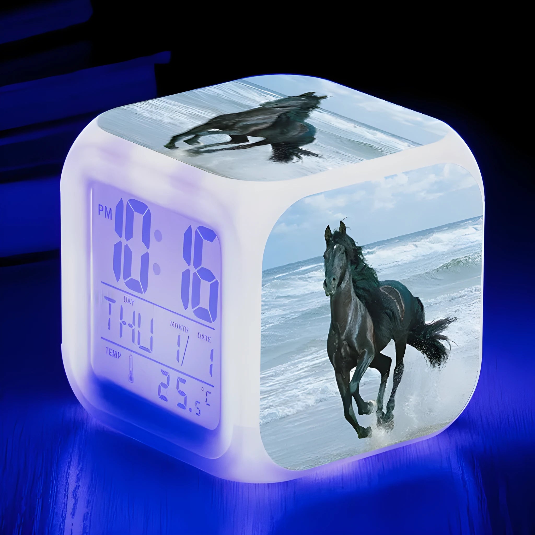 Square cartoon digital alarm clock with colour changing LED display on a plastic and plexiglass body.