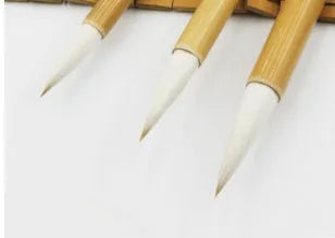 Three traditional Chinese calligraphy brushes with wool hair tips and bamboo handles in large, medium, and small sizes