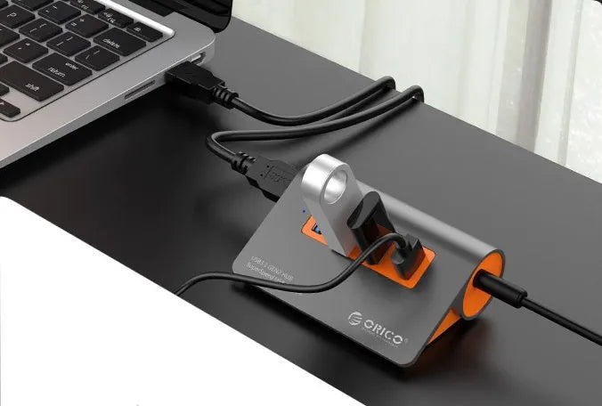 Dark grey and orange aluminium USB hub with 4 ports, separate power unit, and 100cm cable