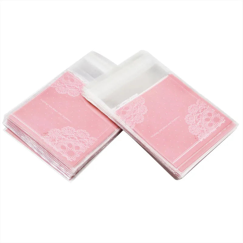Pink self-adhesive plastic packaging bag with a 3cm flap, shown in a pack of 100.