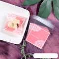 Pink self-adhesive plastic packaging bag with a 3cm flap, shown in a pack of 100.