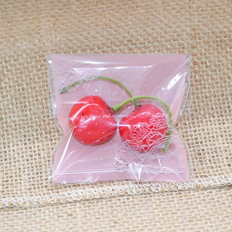 Pink self-adhesive plastic packaging bag with a 3cm flap, shown in a pack of 100.