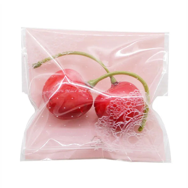 Pink self-adhesive plastic packaging bag with a 3cm flap, shown in a pack of 100.