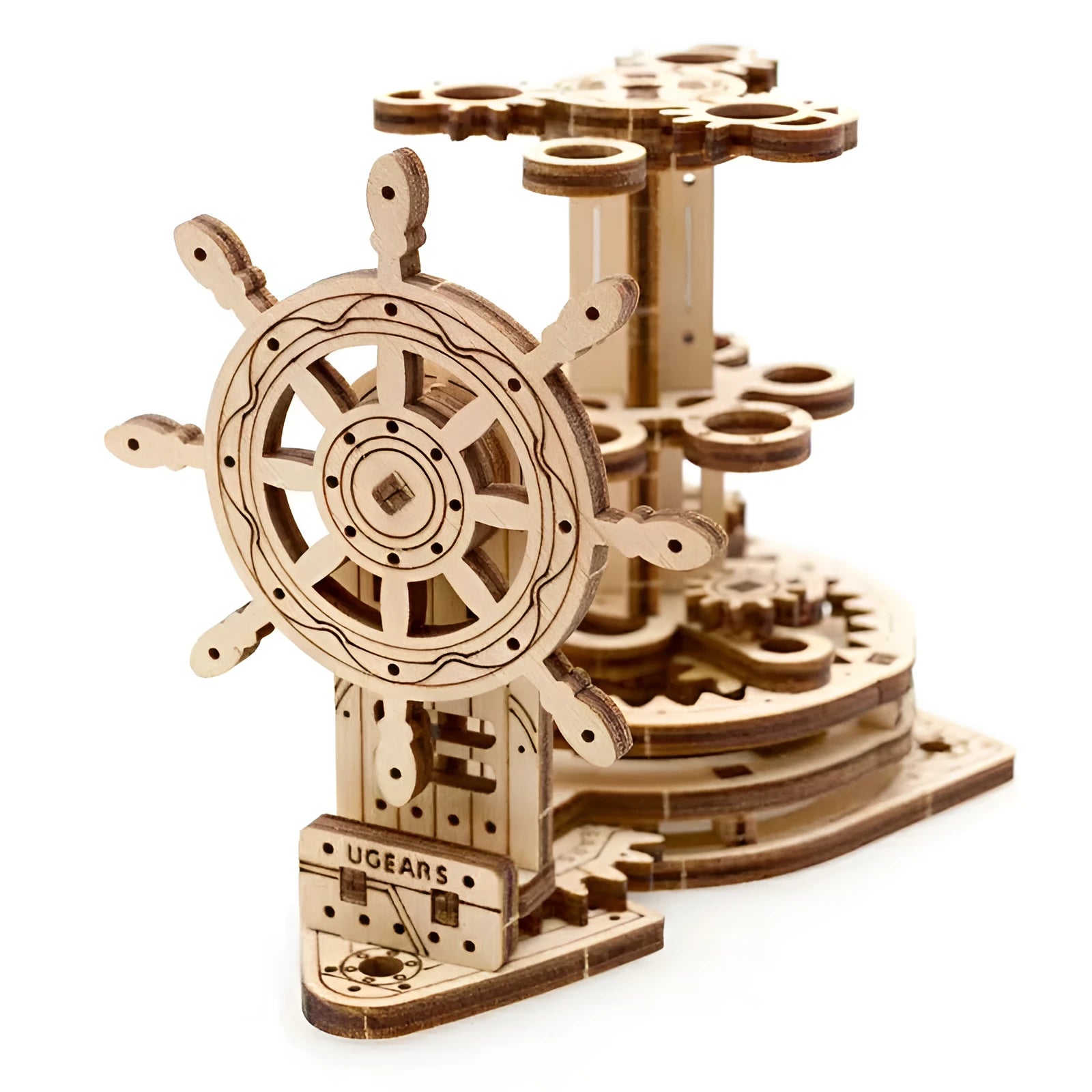 Assembled wooden steering wheel model functioning as a rotating pen holder on a desk.