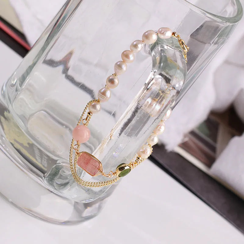 Women's freshwater pearl bracelet with strawberry crystal charm in geometric design on pink background