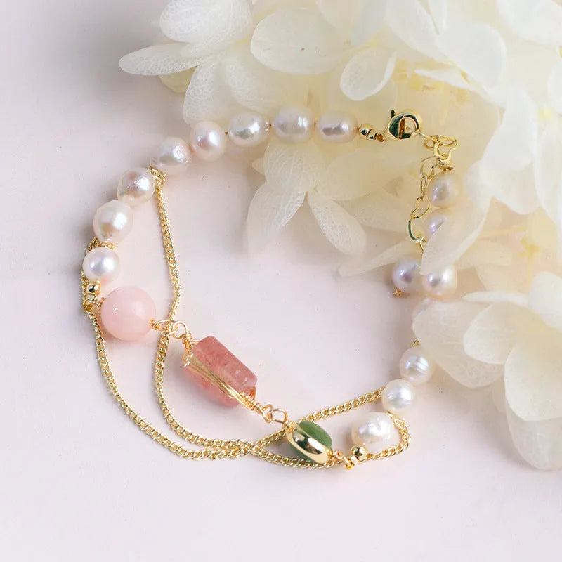 Women's freshwater pearl bracelet with strawberry crystal charm in geometric design on pink background