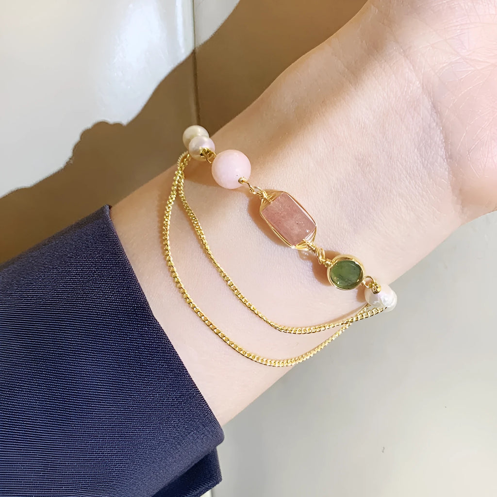 Women's freshwater pearl bracelet with strawberry crystal charm in geometric design on pink background