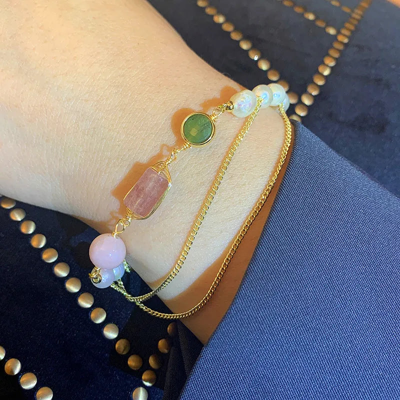 Women's freshwater pearl bracelet with strawberry crystal charm in geometric design on pink background