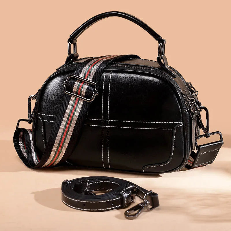 Round leather handbag with soft handle and zip opening in wine red colour