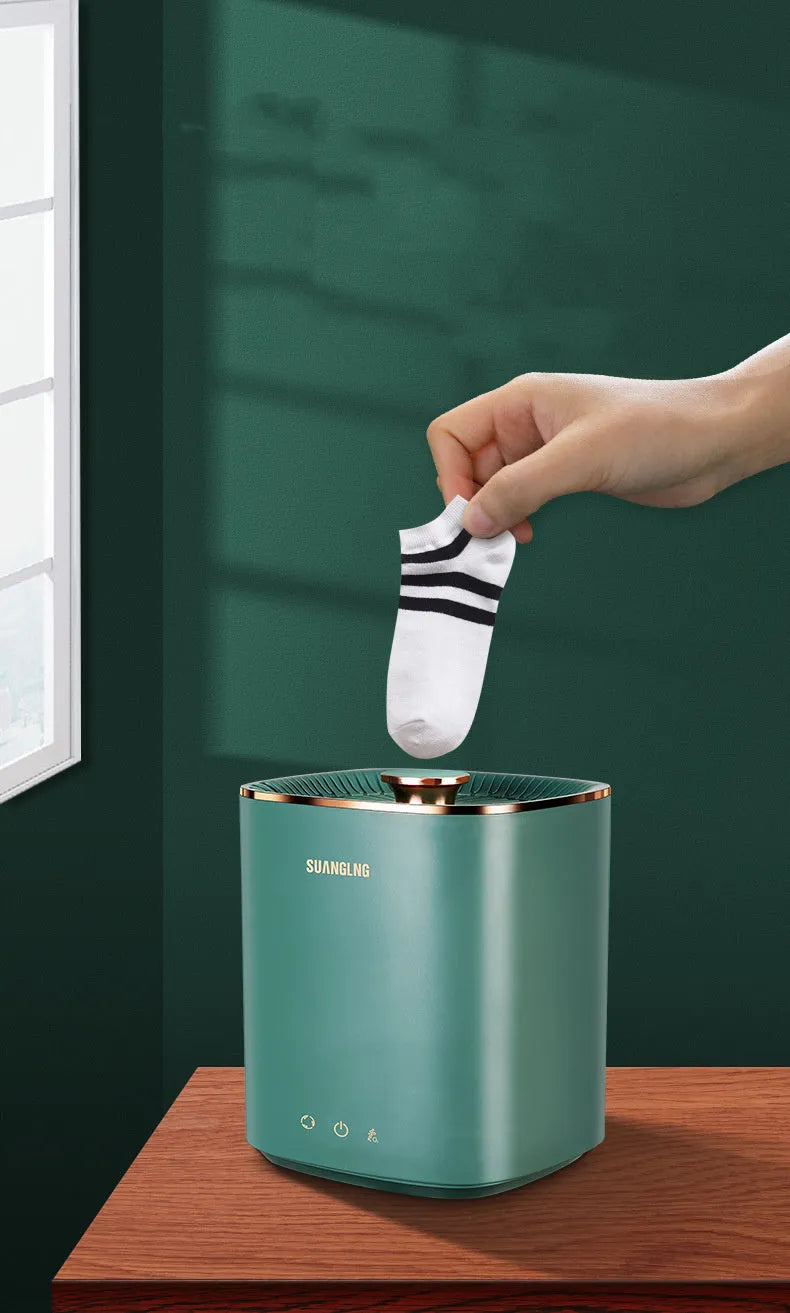 Green and white mini portable washing machine for underwear and socks on a countertop.