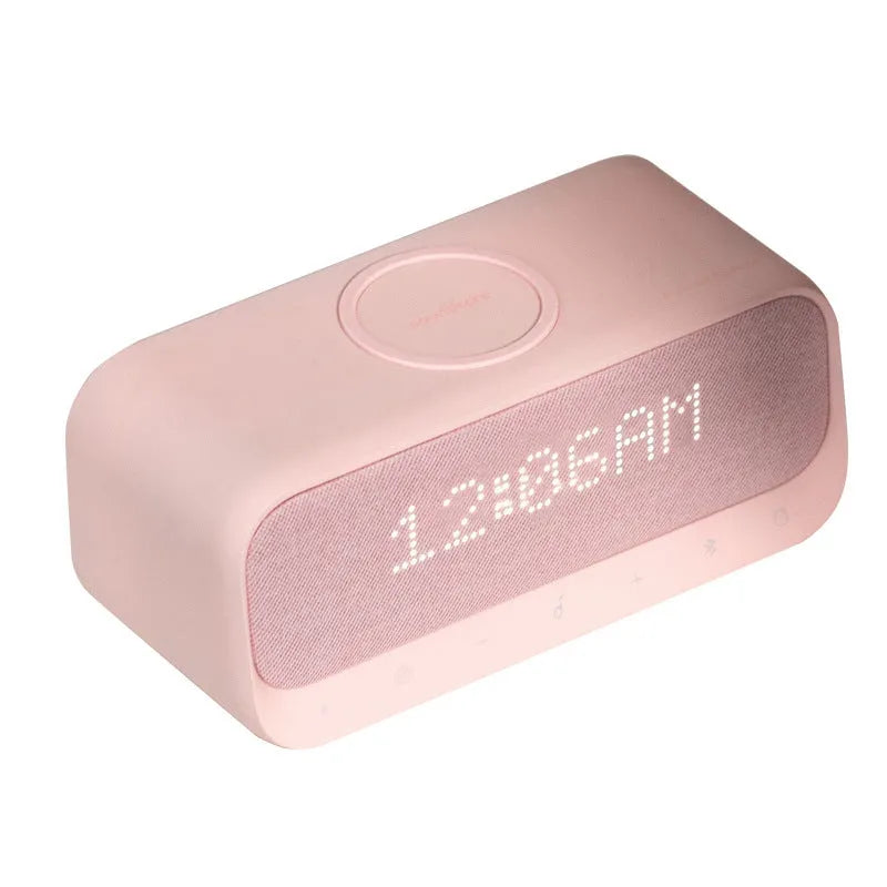 White or pink Anker Soundcore Bluetooth speaker with wireless charging pad and digital clock display