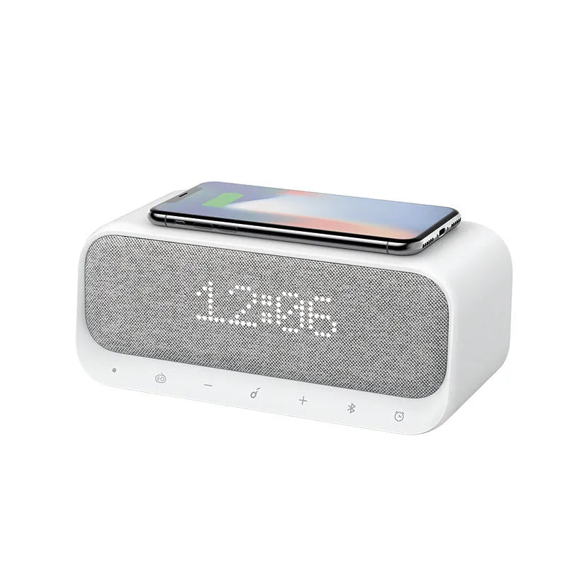 White or pink Anker Soundcore Bluetooth speaker with wireless charging pad and digital clock display