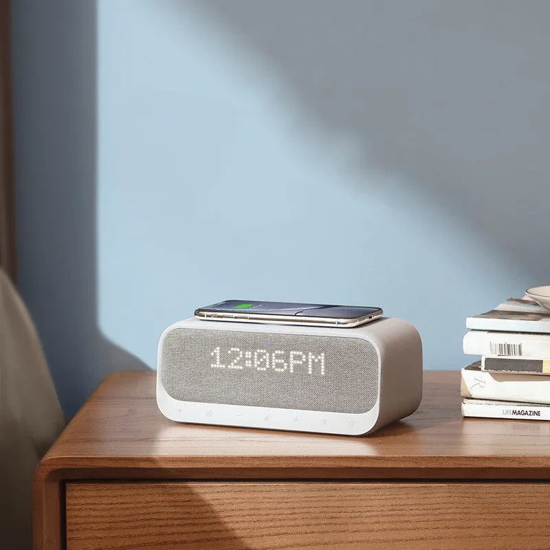 White or pink Anker Soundcore Bluetooth speaker with wireless charging pad and digital clock display