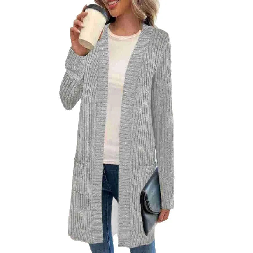 A woman's long sleeve loose-fit knitted cardigan jacket with pockets in wine red.