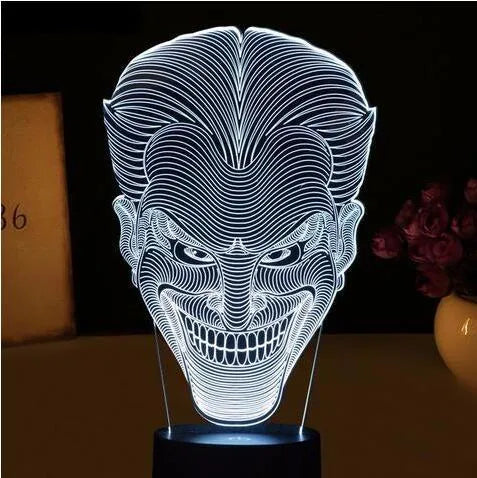 A 3D acrylic LED lamp displaying a gradient of colours, sitting on a square base with a USB cable.