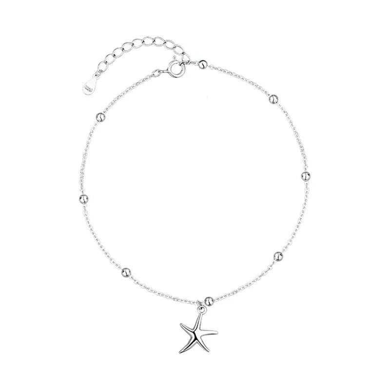 Close-up of a sterling silver anklet with a starfish charm on a round beaded chain.