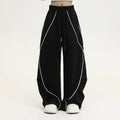 Black pleated wide-leg trousers with stripe pattern showing loose fit and mid waist design