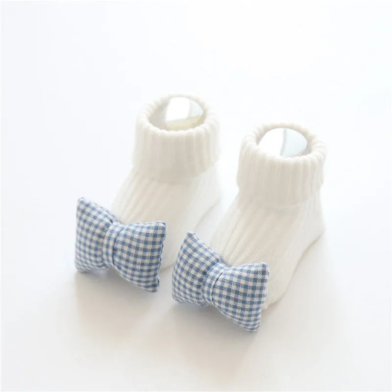 Cotton baby floor socks in various designs including blue bow and lion, showing sizes for infants 0-3 months