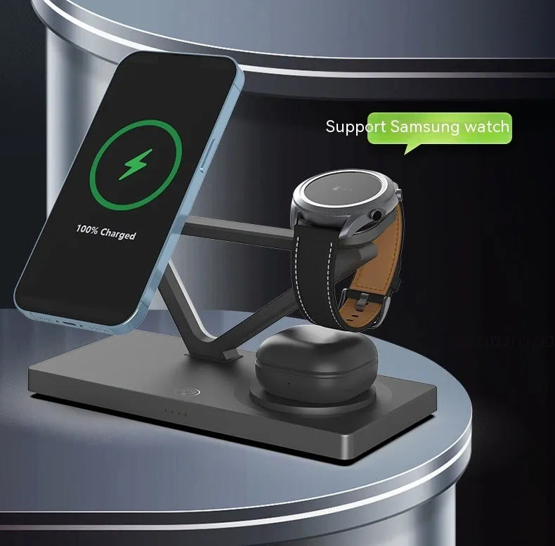 White five-in-one wireless charging station with magnetic phone bracket, circular charger, watch pad, and night lamp on desk.