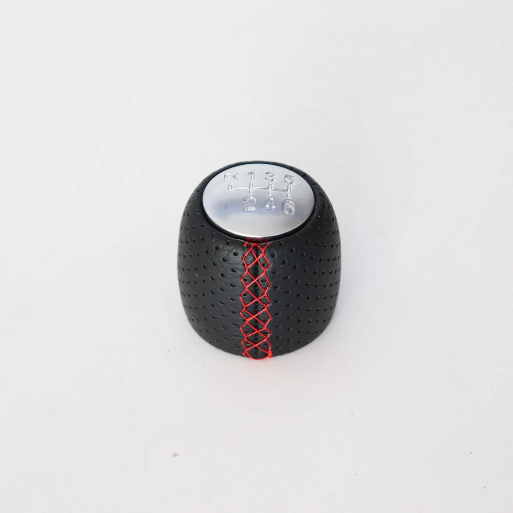 Black perforated PU leather gear knob for Alpha car with sewn seam, shown next to red and white line options.