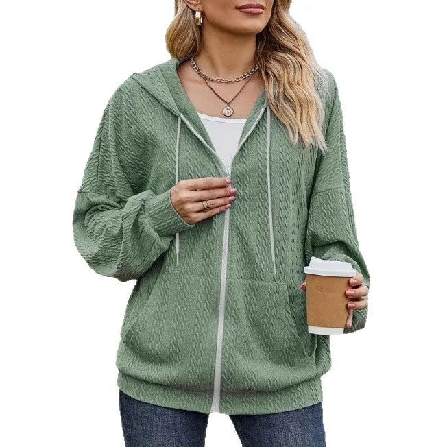 Green women's hooded sweater coat with front zipper, shown on a model in a casual setting.