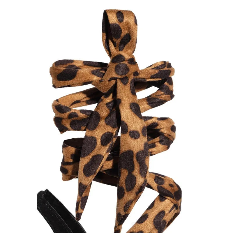 Light brown leopard print high heel shoes with cross strap design and stiletto heel