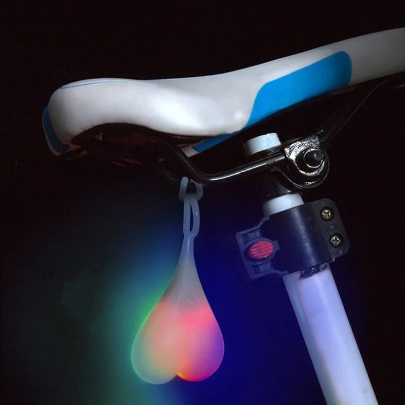 Heart-shaped silicone bike rear light, 15 cm long, touch activated, waterproof, in red blue green.