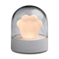 Grey and pink cat paw shaped USB rechargeable night light with adjustable brightness on a desk.