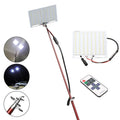 White LED fishing rod light unit with remote control next to extended telescopic pole