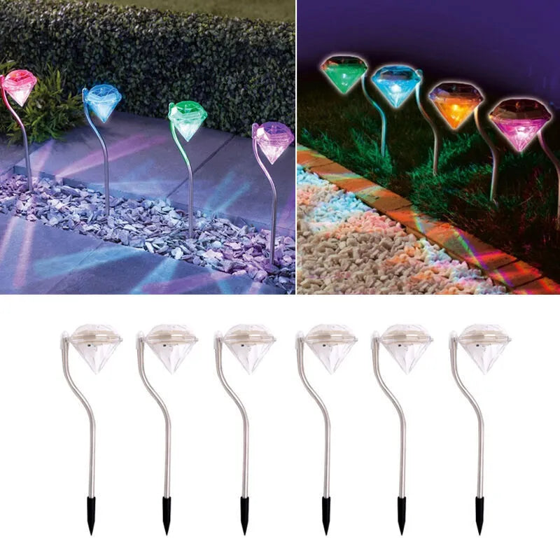 White solar-powered LED garden spotlight with adjustable angle and solar panel on a stake.
