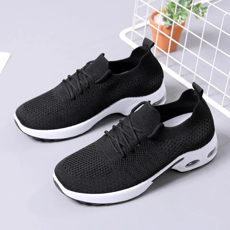 Women's grey lace-up sneakers with mesh upper and soft PVC sole on a light background.