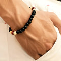 Unisex natural stone bead bracelet with lava stones for essential oils, ethnic style, on a wrist.