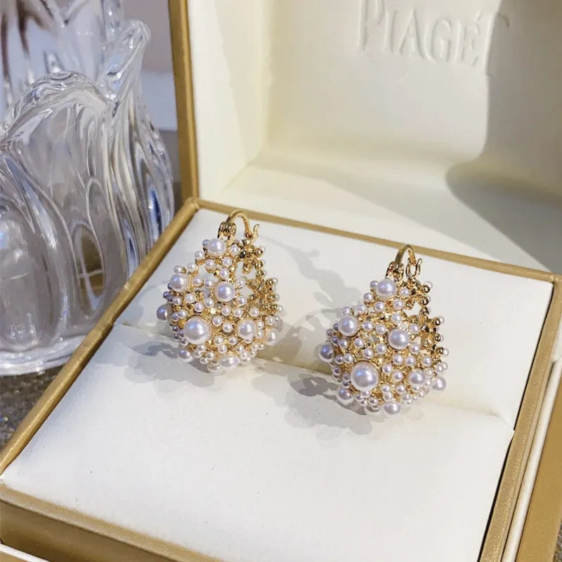 Gold women's copper earrings in a flower basket shape decorated with small rice-shaped beads.
