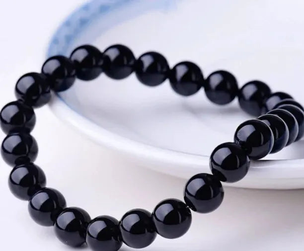 Geometric black agate bracelet with 8mm beads on a black elastic cord for women.